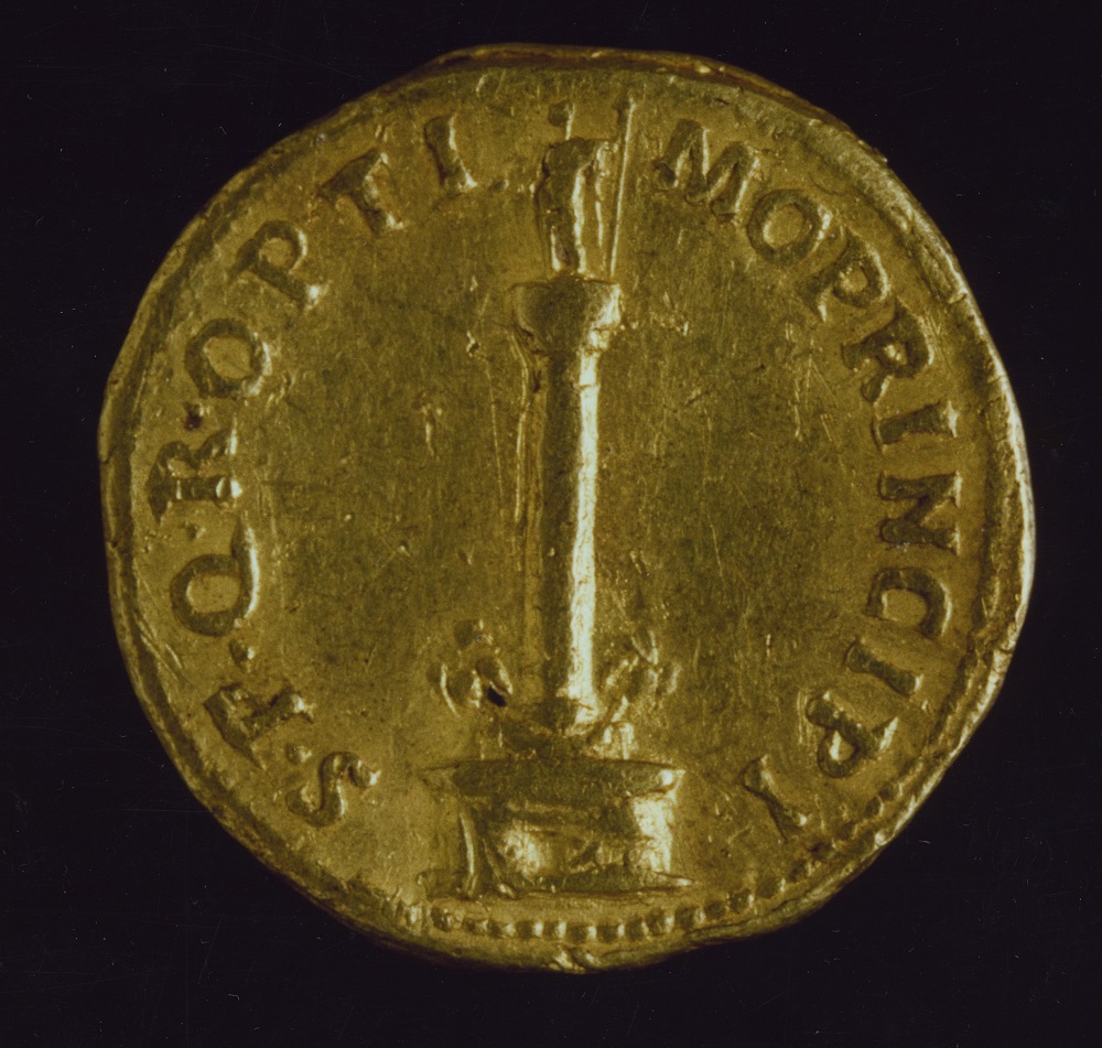 Trajan gold coin with the image of the Trajan's Column. On the top: the statue of Trajan